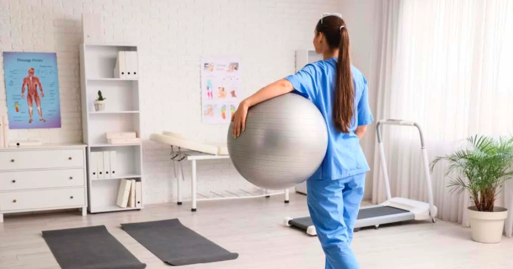 Nurse standing with good posture holding an exercise ball and performing light exercises, demonstrating strength training and injury prevention for healthcare professionals.